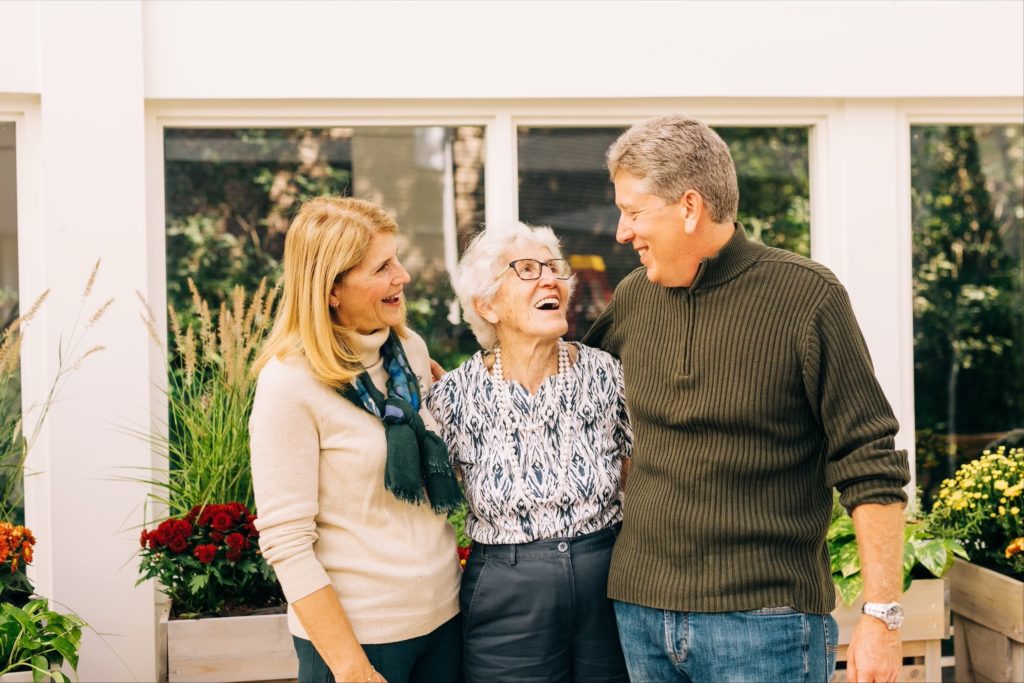 elderly woman standing with family members