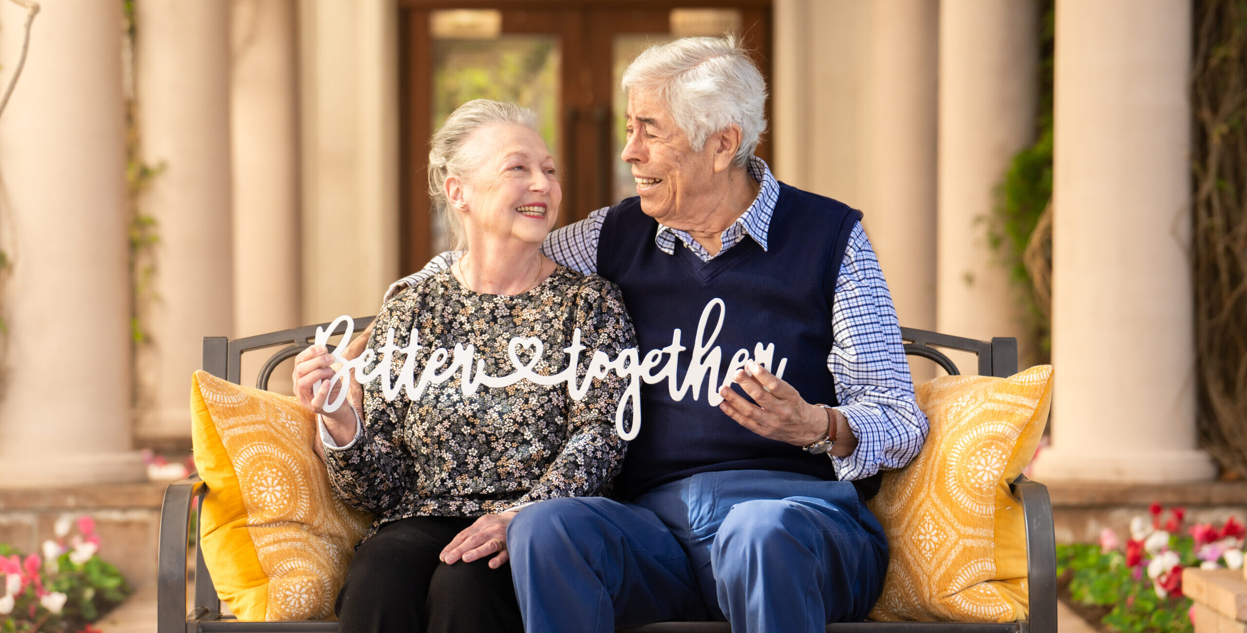 Senior couple with sign that reads better together