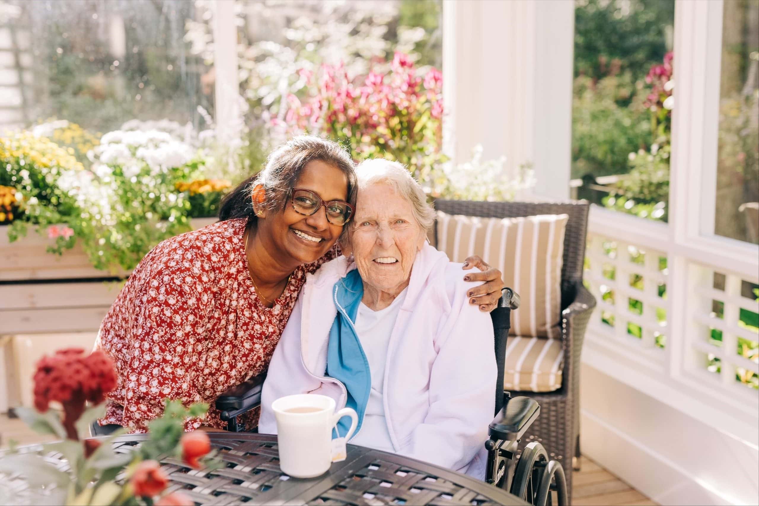 healthcare professional and resident smiling in a garden