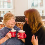 Aging Mother and Daughter drinking hot cocoa