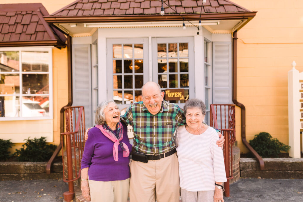 older man smiling with two older women