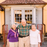 older man smiling with two older women