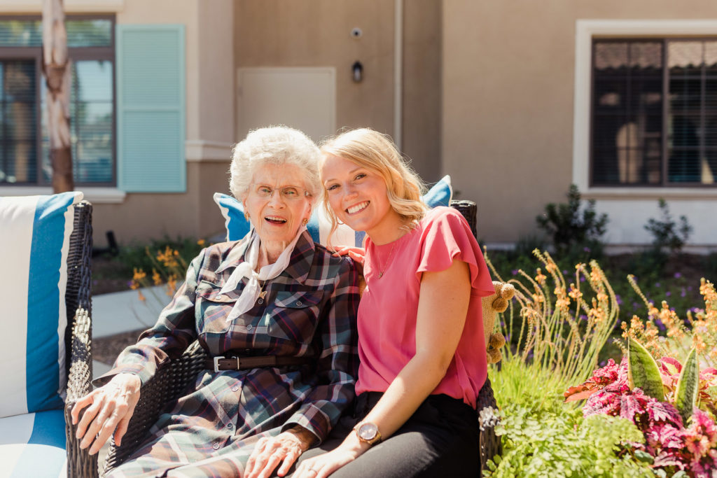 team member and resident smiling outside
