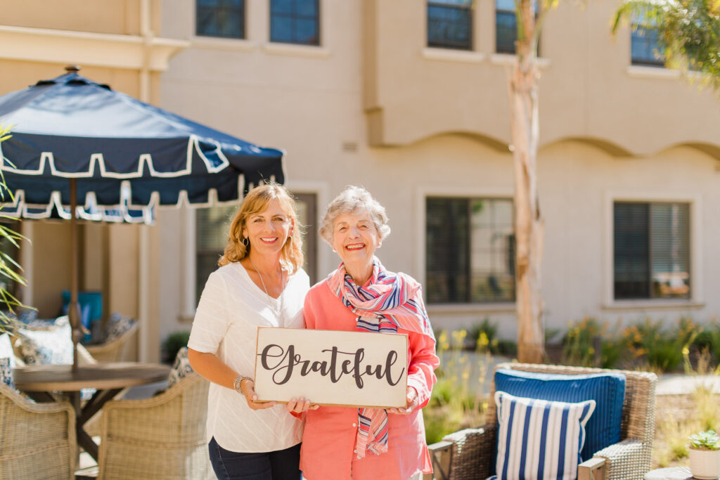 two women holding sign that says grateful