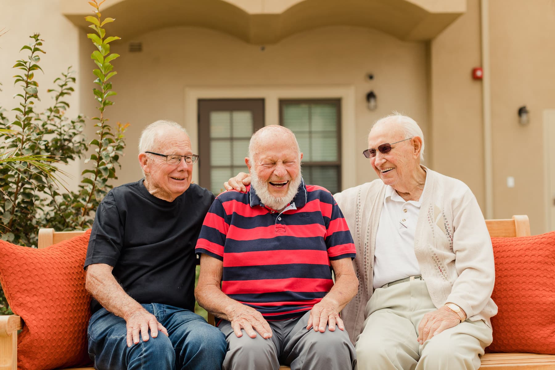 three elderly men sitting on a bench together