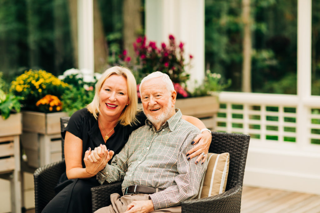 senior father and daughter holding hands in a garden