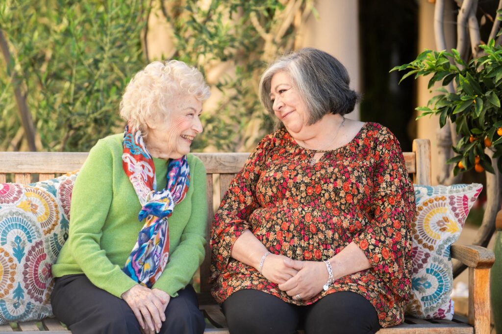two women sitting on bench together
